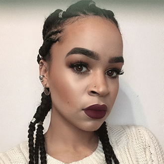 a person with long braids and dark lipstick
