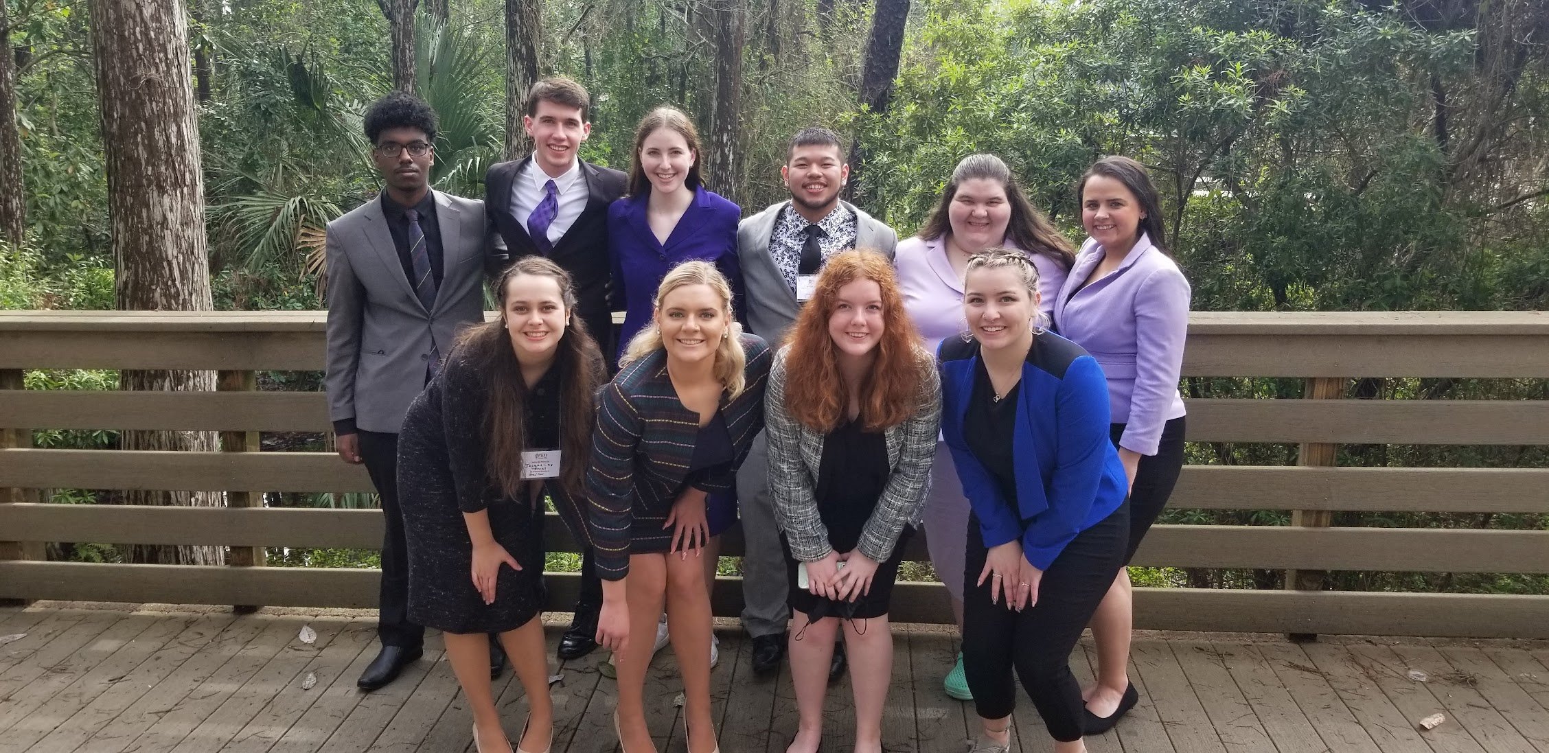 Minnesota State University speech and debate team gathered together posing for a group photo outside on a bridge