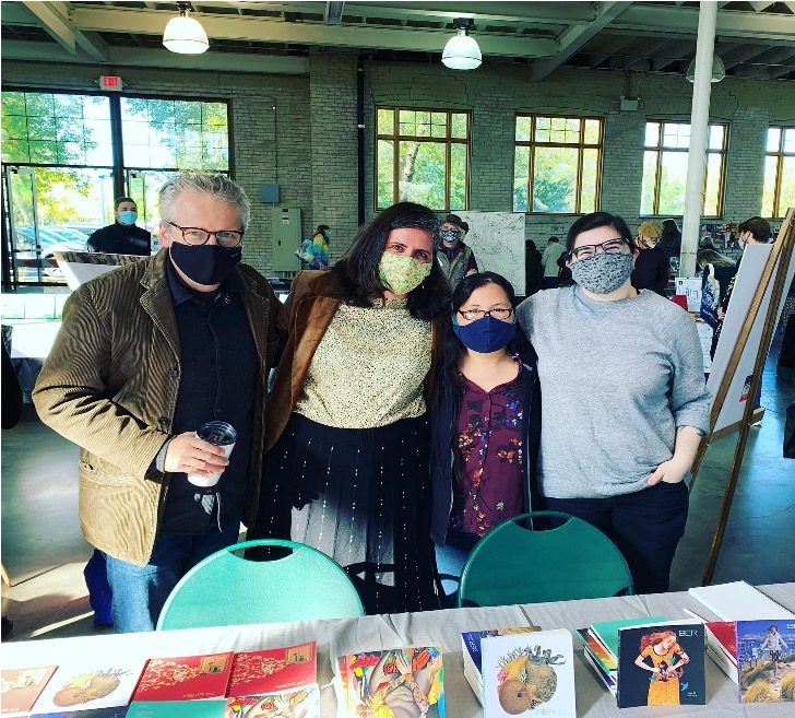 4 peoplewith masks on, 3 women and 1 man standing together for a picture