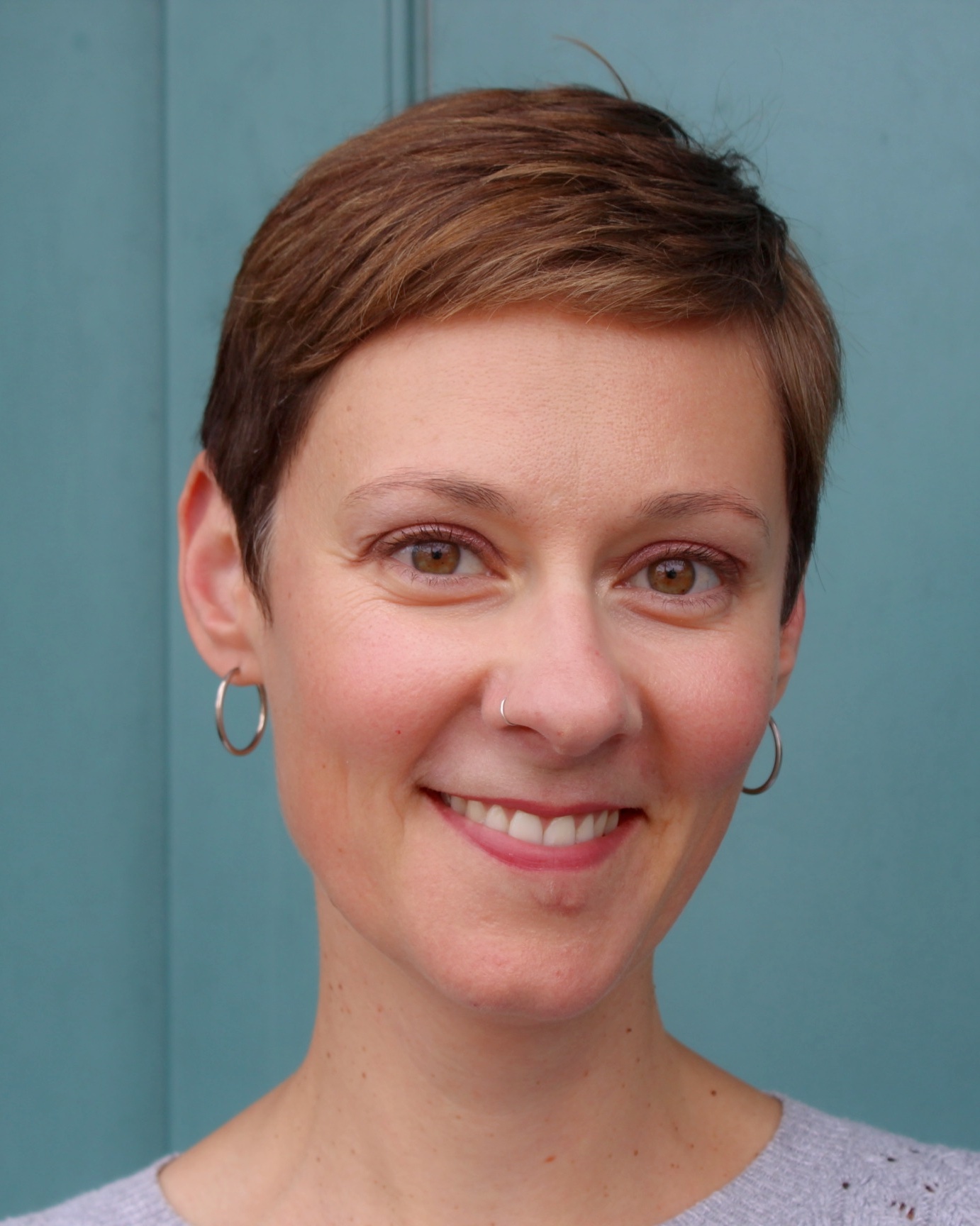 a person with short hair and earrings