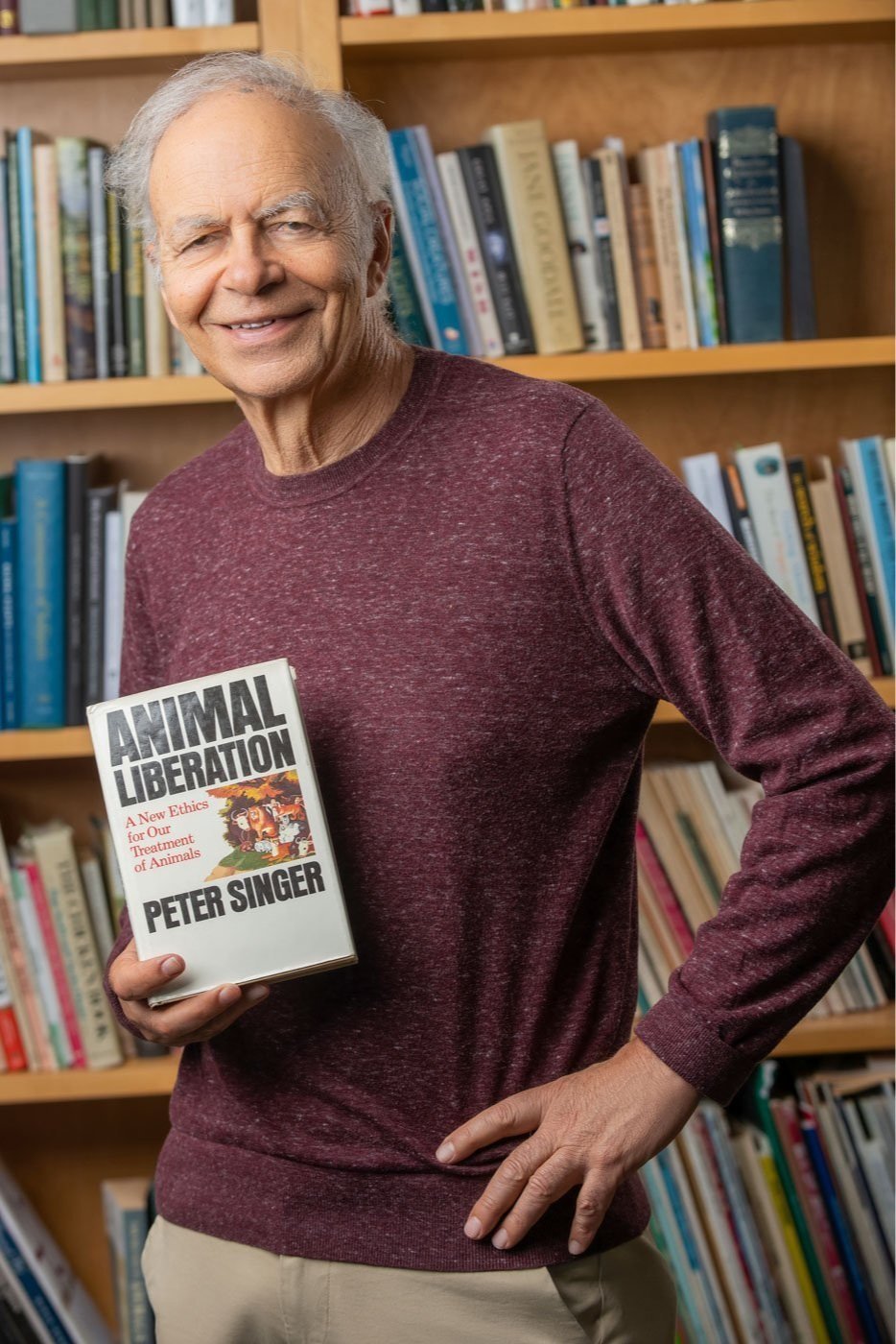 Peter Singer holding a copy of his book Animal Liberation